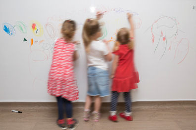 children using the whiteboard wall to draw on