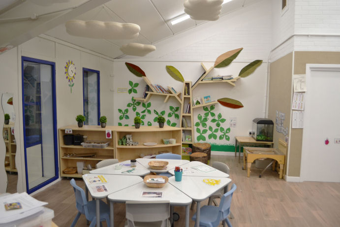 a library tree shelf in a reading corner and acoustic clouds hang from the ceiling