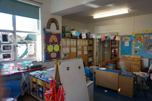 an art easel and storage, lots of colourful displayed work