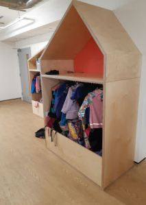 coats hanging in the house shaped cloakroom unit