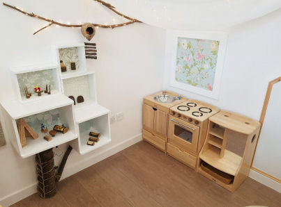 a home corner has a play kitchen and Nature inspired decoration