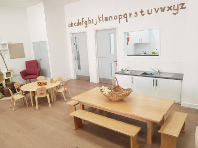 Dining area with kitchen hatch, sinks and table with benches