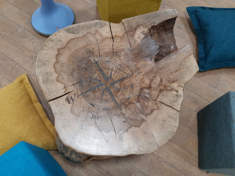 A rustic table with a compass image on the top