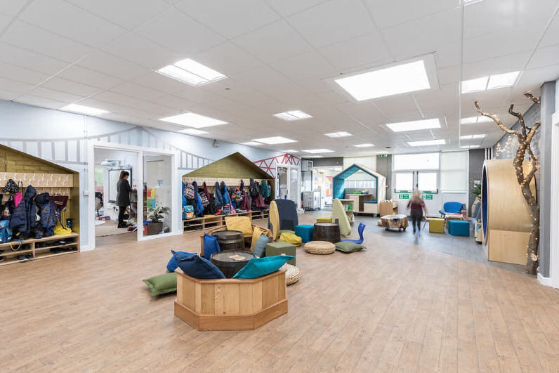 the general purpose room is bright and airy, there is a wooden boat to sit at with cushions and wicker seat pads, the cloakrooms are golden and house shaped recessing into the wall. there is a tree with fairy lights