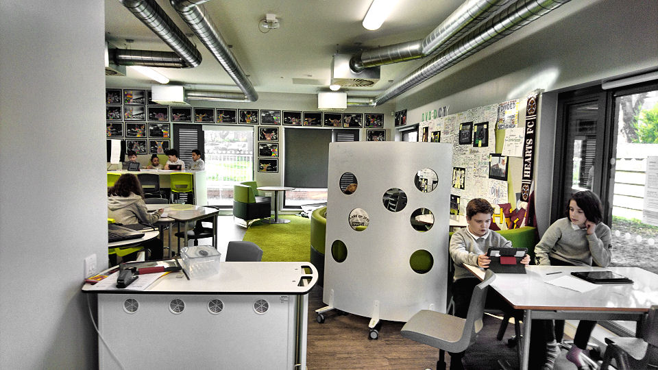 two boys work together by the window a screen with holes in it gives a feeling of privacy