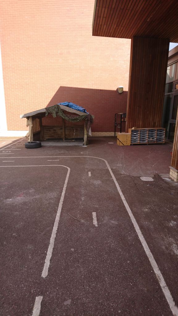 a tarmac playground that has line markings creating a bicycle track