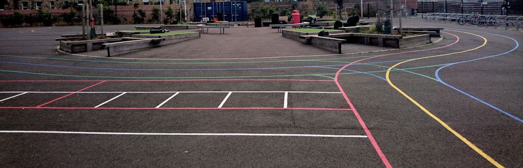 a tarmac playground with colourful line markings