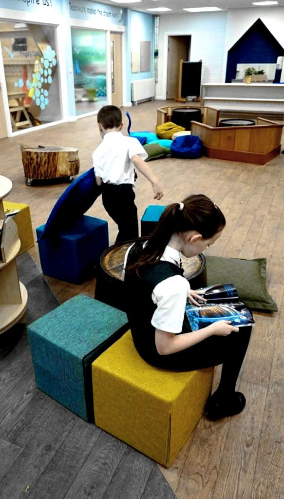 children sitting on cube stools