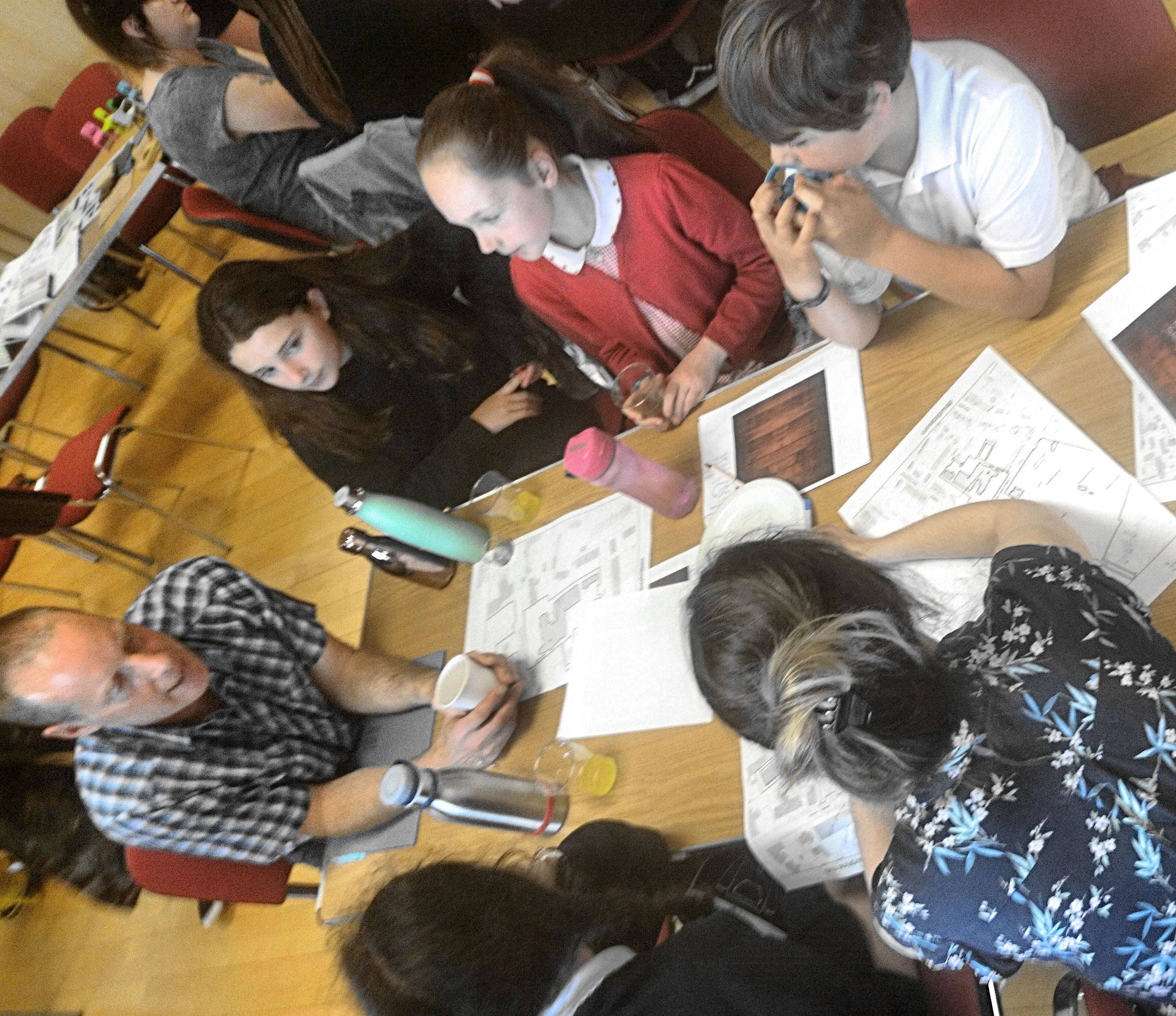children sit around a table talking about their design