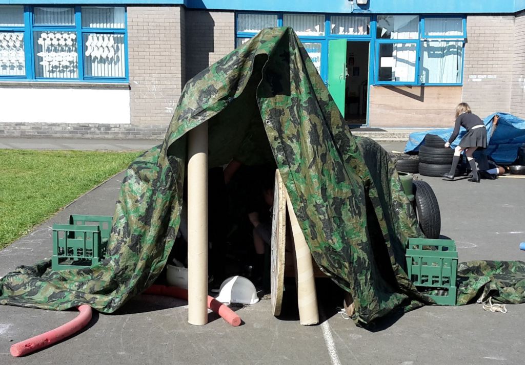 A den made from cardboard, tarpaulin, crates and tyres