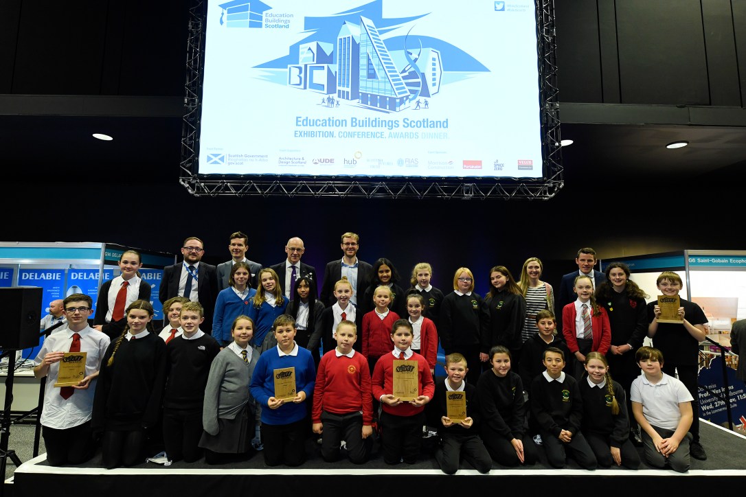 all of the learners from the finalists pose on stage together with their trophies