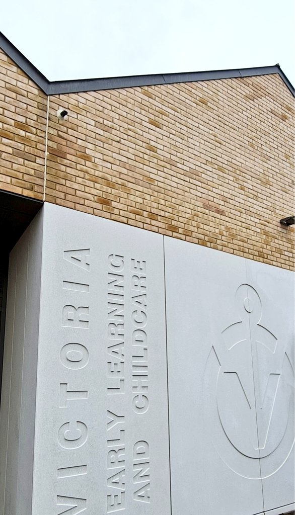 Stone carving of the school logo and name