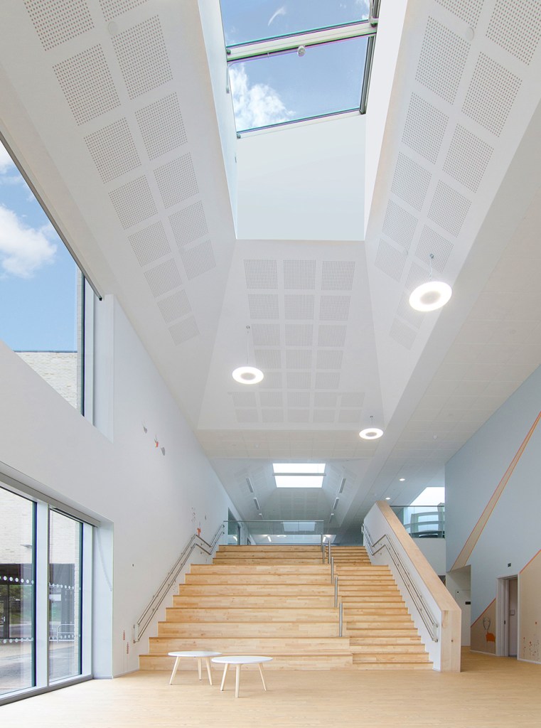 The school foyer, a bright two storey space, roof lights and large windows on the left wall let in a lot of daylight. A staircase and hellerup stair lead to the first floor.